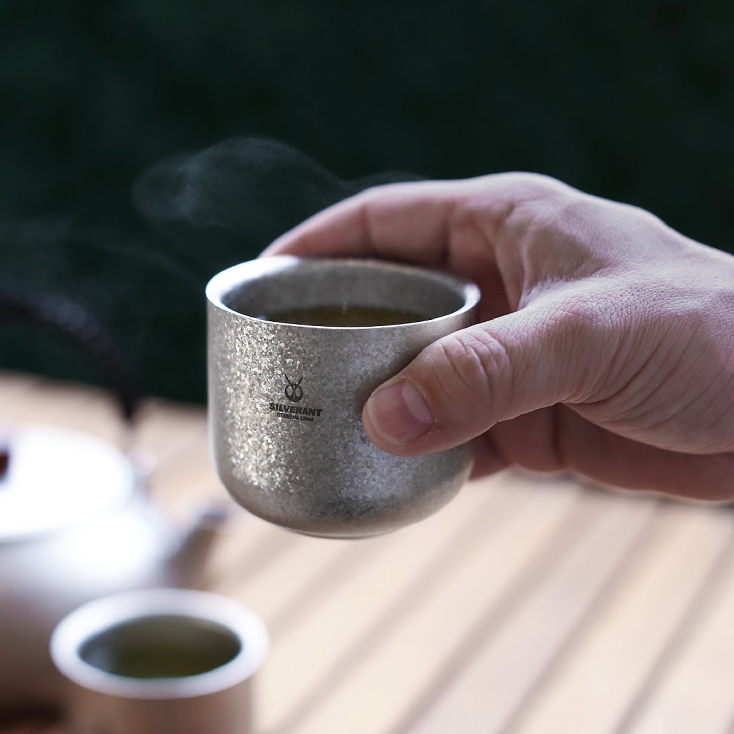SilerAnt Outdoors Titanium Tea Cup Double Wall 125ml/4.22 fl oz Crystallized Finish in-use image full of hot tea held in right hand