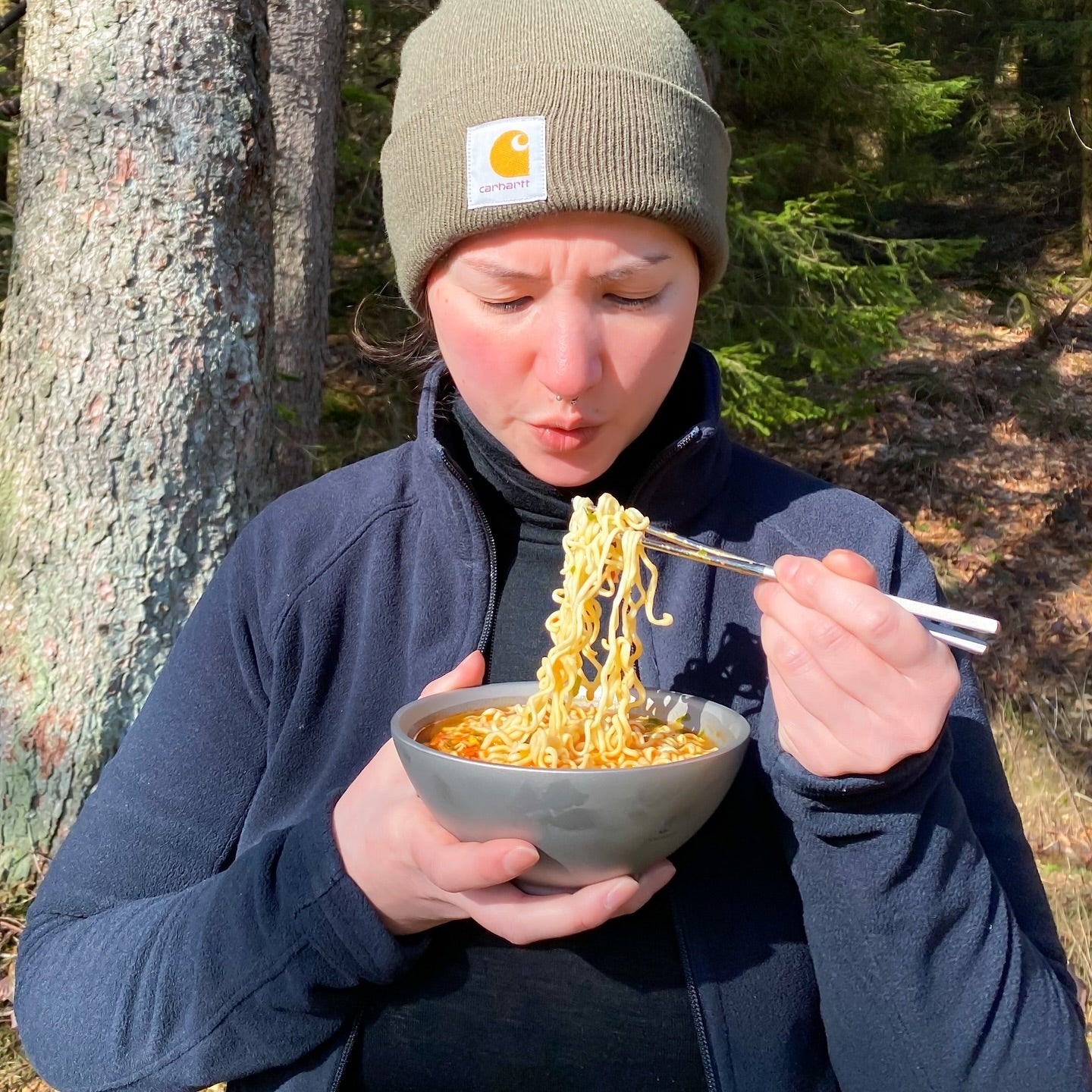 Ultralight Titanium Chopsticks - a lady is eating instant noodles with them from a SilverAnt titanium double-wall bowl