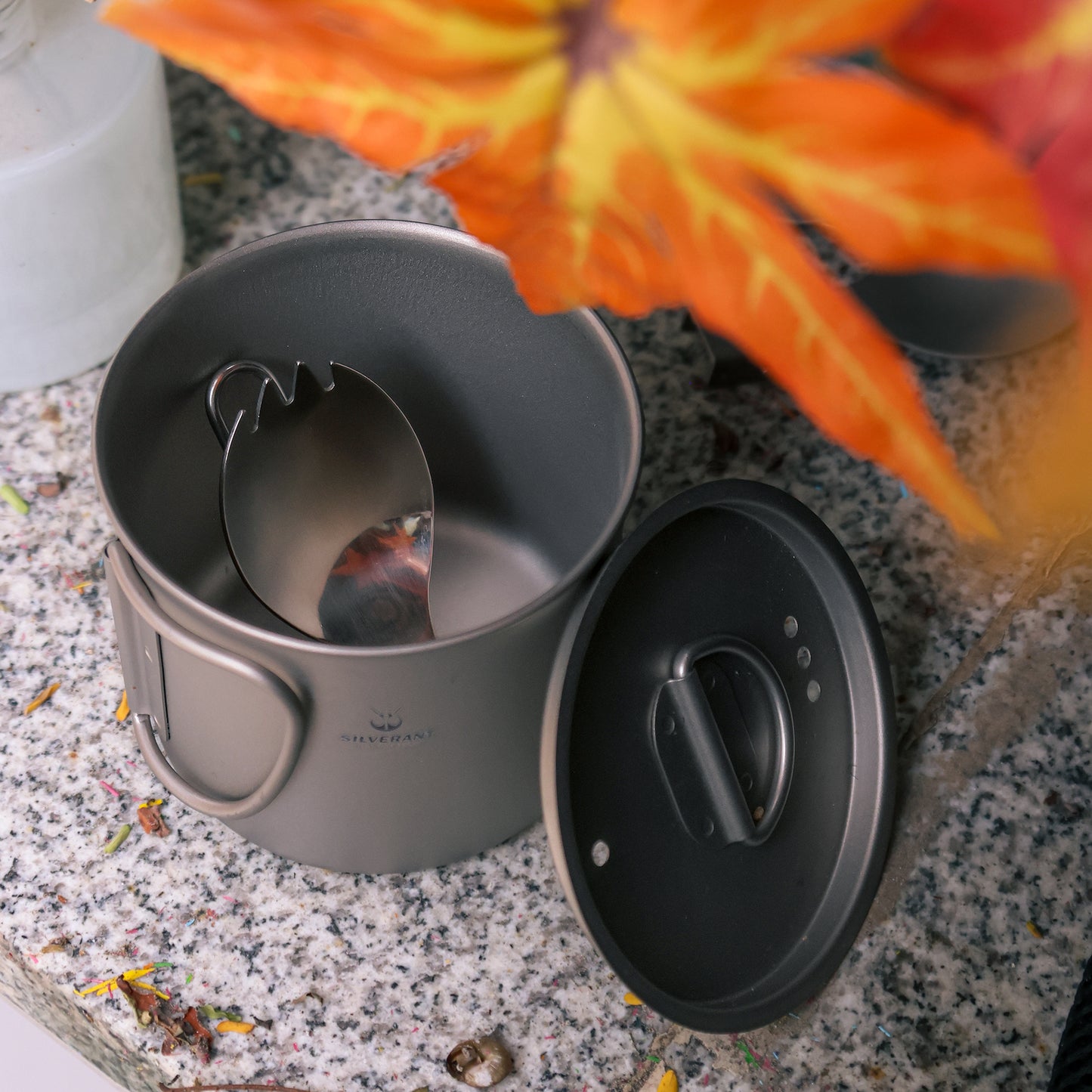 Ultralight Titanium Folding Spork with polished finish folded and placed in a titenium cup image