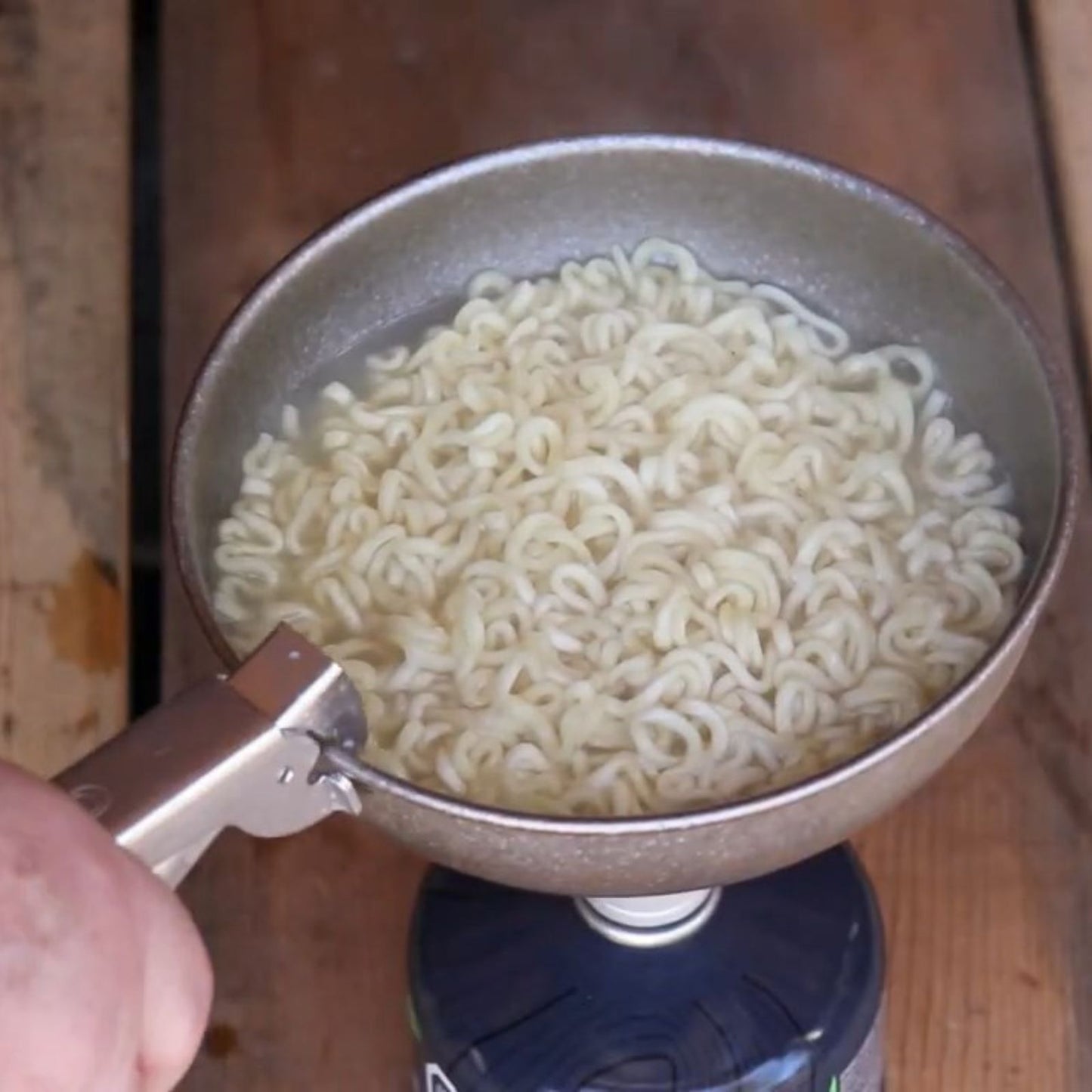 SilverAnt Titanium Camping Bowl 500ml/16.91 fl oz Crystallized Finish - in use image - cooking noodles on a stove