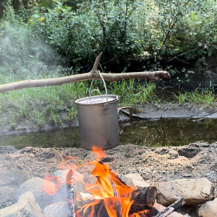 
                  
                    Titanium Pot 750ml/25 fl oz with Lid and Bail Handle - boiling water hung on a branch
                  
                