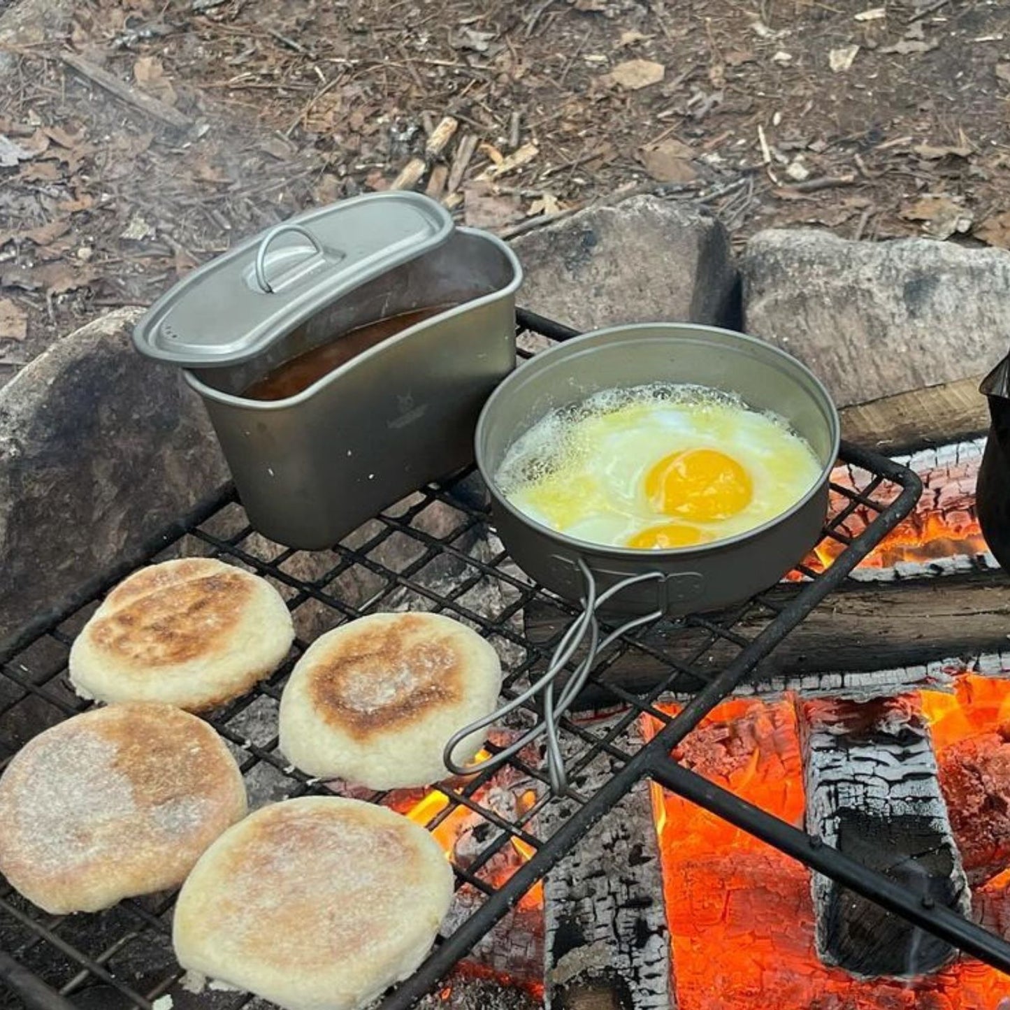 
                  
                    Ultralight 2-Piece SilverAnt Titanium Cookware Set in use image - frying eggs in the pan on a grill net
                  
                