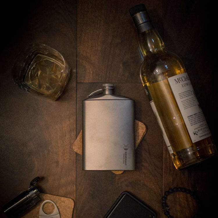 titanium flask and bottle on a wooden surface