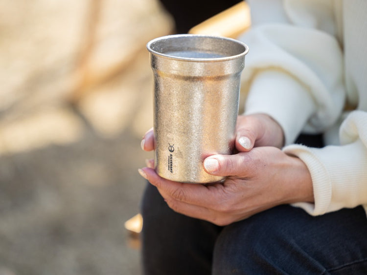 Woman holding titanium beer cup