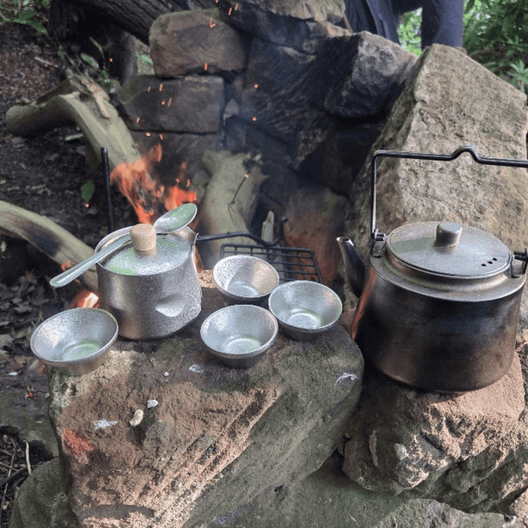 
                  
                    SilverAnt Crystallized Titanium Breeze Travel Teapot & Cups Set - actual product photo, lifestyle shot, real life use, in use, placed on top of a rock with campfire in the back
                  
                
