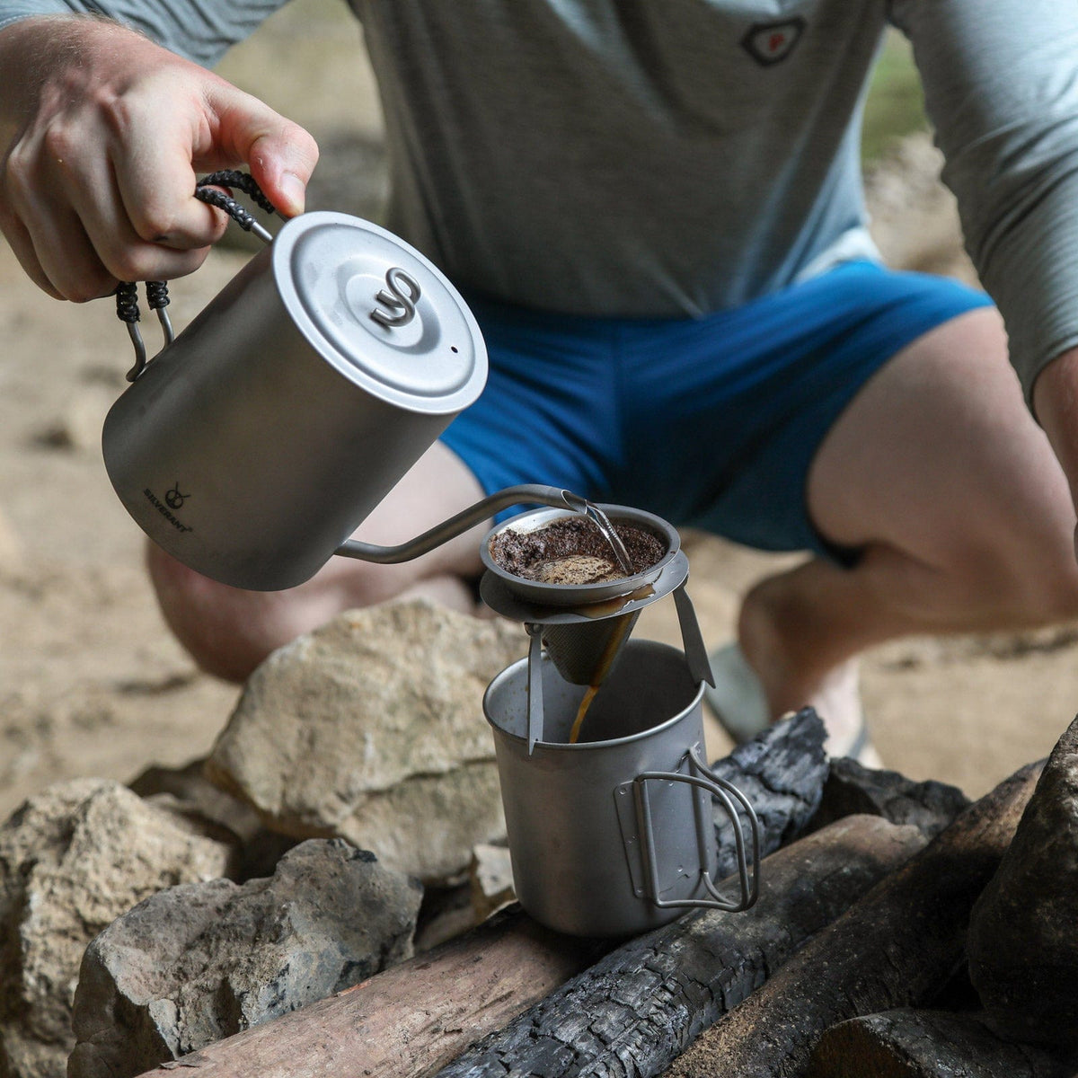 SilverAnt Titanium Pour Over Kettle Sandblasted 950ml/33.4 fl oz - Actual product photo, in-use, on hand, pouring onto coffee filter in the outdoors, camping scene