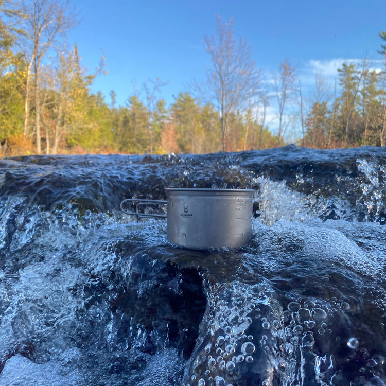 
                  
                    SilverAnt Ultralight Titanium 3-Piece Camping Cookware Set - In-Use (River, titanium pot, water rushing, forest background)
                  
                