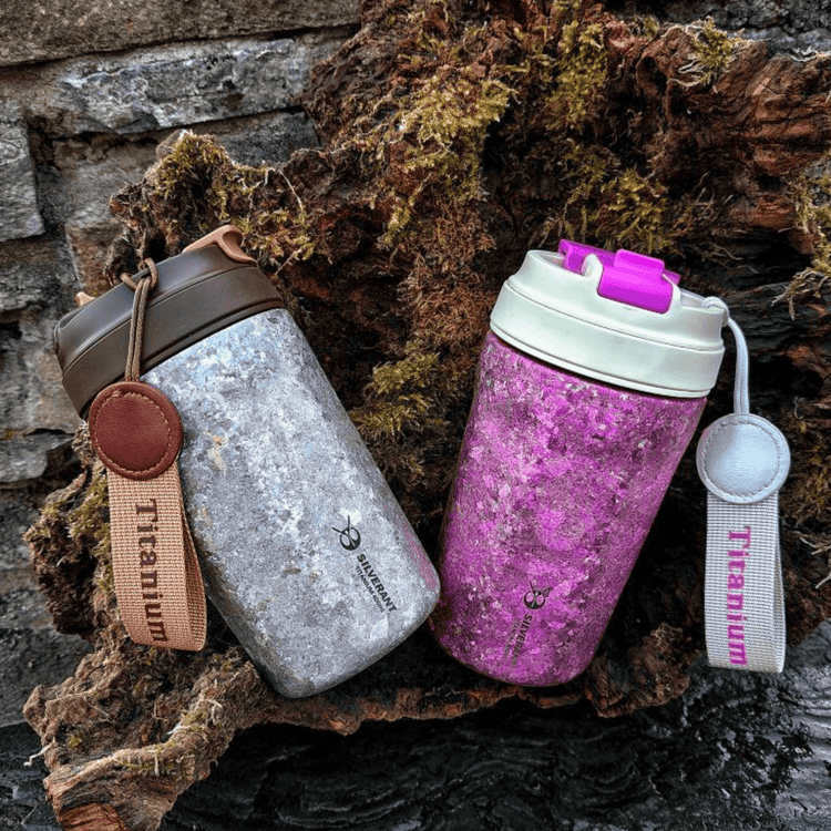 
                  
                    SilverAnt Ultralight Crystallized Titanium Insulated Travel Coffee Mug with Lid 400ml/14 fl oz Classic Silver and Bold Purple side-by-side on a mossy tree bark
                  
                
