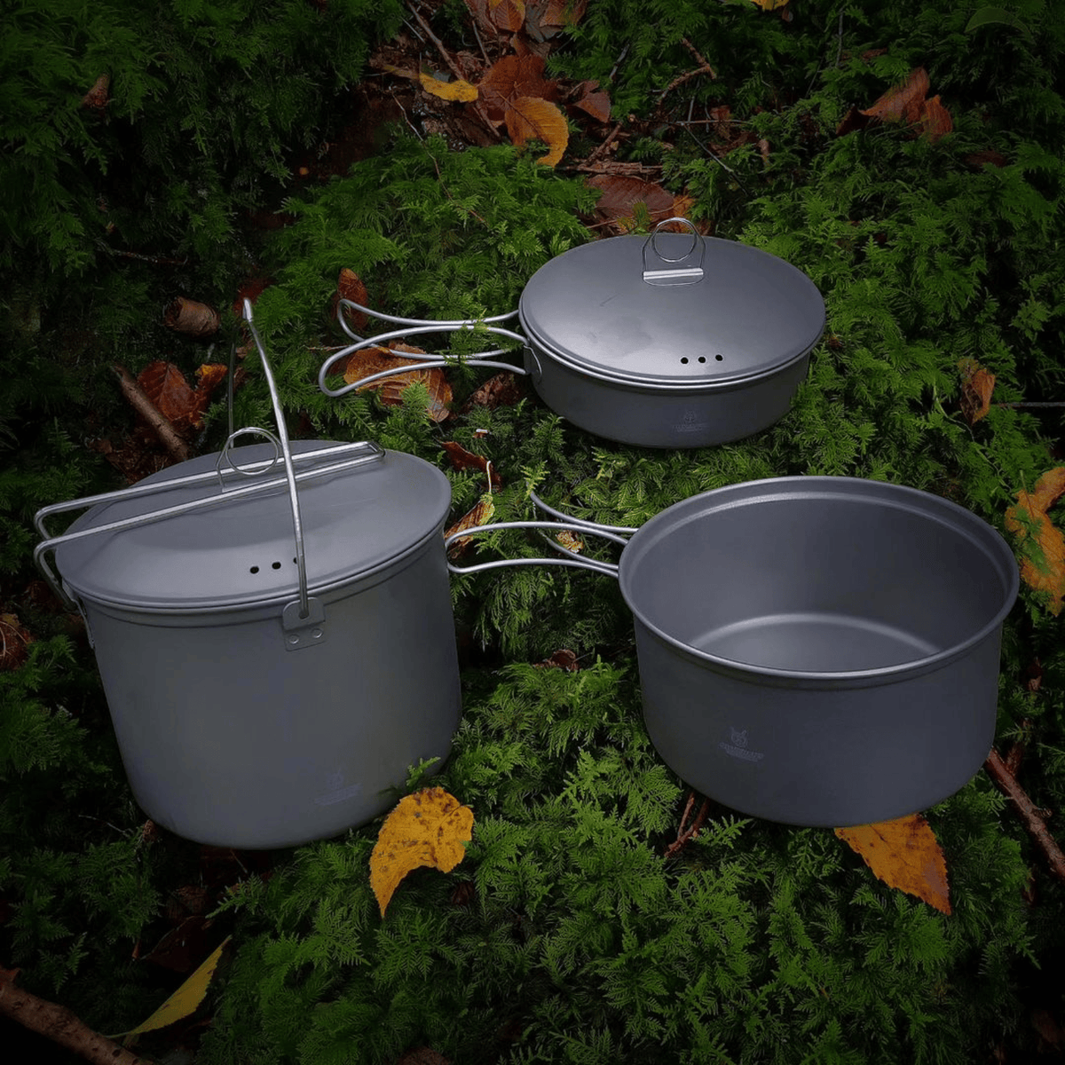 SilverAnt Ultralight 3-Piece Titanium Cookware Set - In-Use (laid out in grass/forest floor, sandblasted finish, cookware set)
