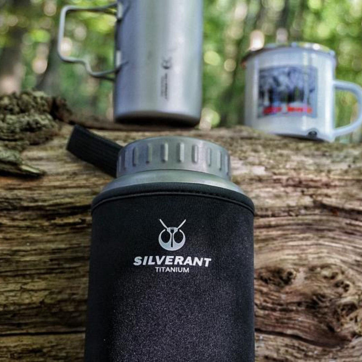 SilverAnt Ultralight Large Titanium Water Bottle (Wide Mouth) - In-Use (Lifestyle photo, actual product photo, black thermal sleeve with SilverAnt branding, outdoors)