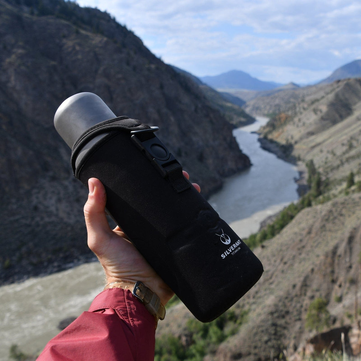 SilverAnt Ultralight Large Titanium Water Bottle With Titanium Cup - In-Use (actual product photo, black thermal carry sleeve, overlooking beautiful view)