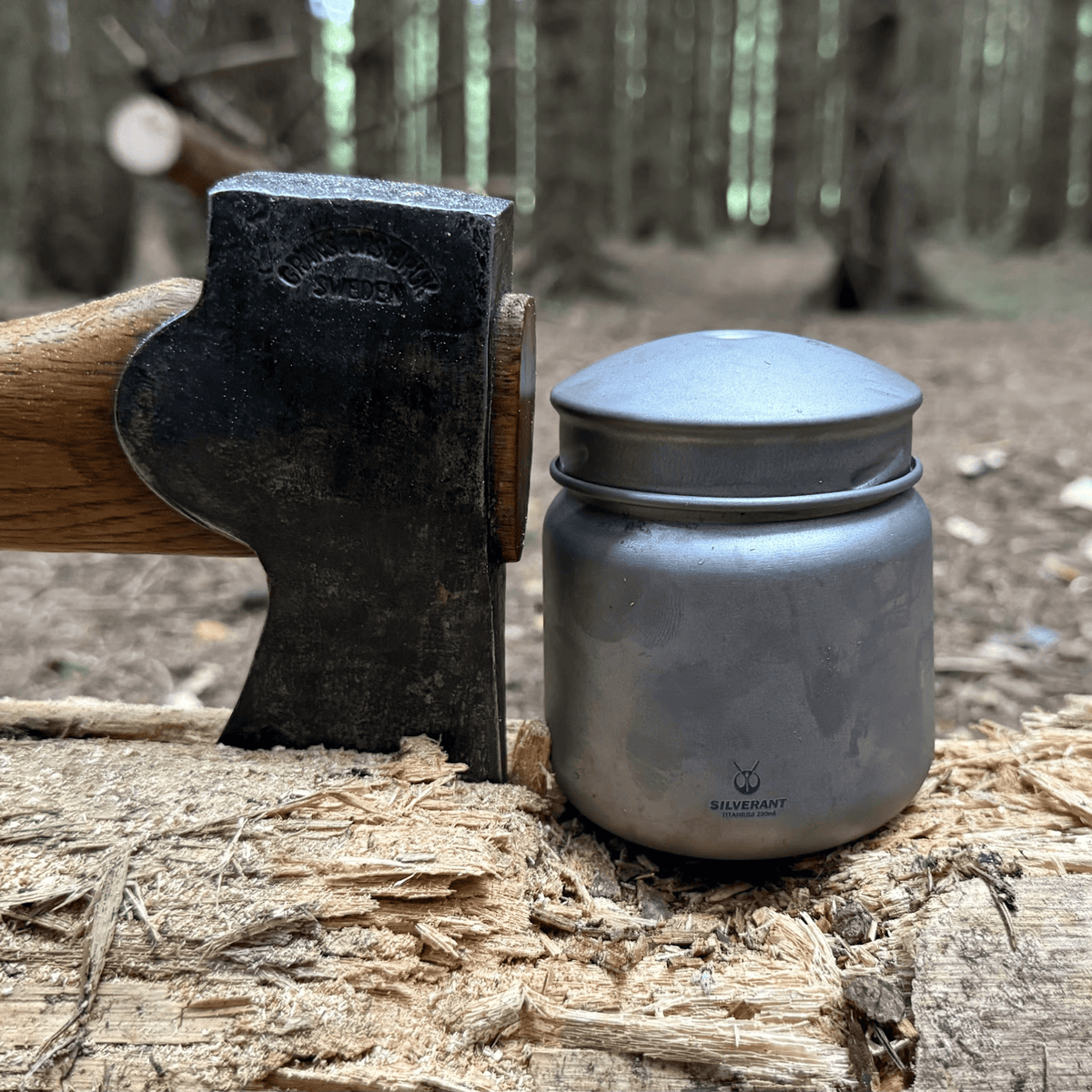 SilverAnt Ultralight Leakproof Titanium Container 280ml / 9.47 fl oz Sandblasted (actual product photo, placed on op of a tree log, with an axe wedged into the log by its side)