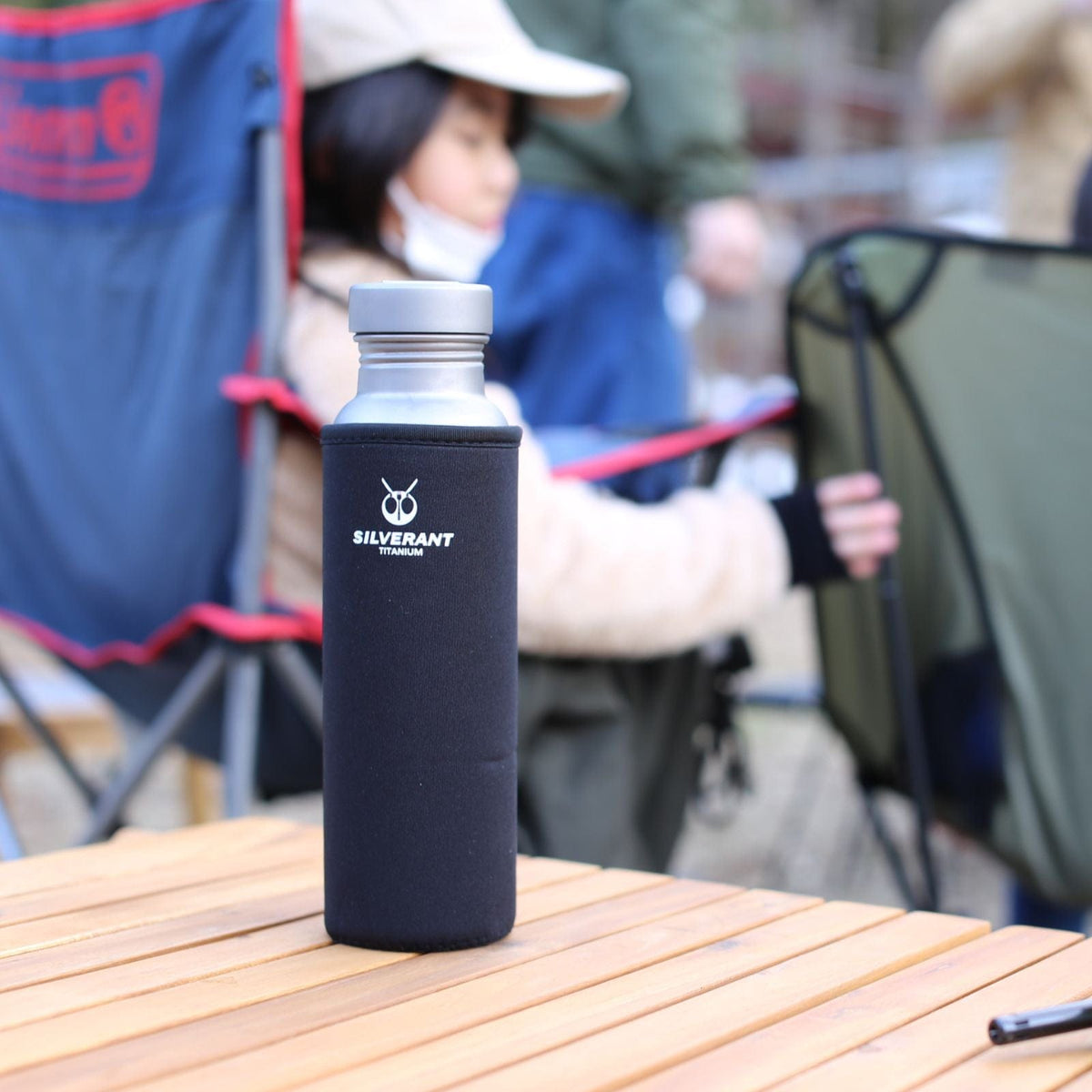 SilverAnt Ultralight Round Titanium Water Bottle - In-use (with black thermal sleeve, SilverAnt branding)