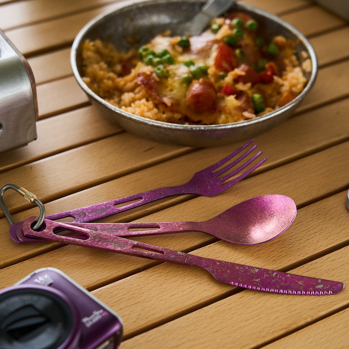 SilverAnt Ultralight Titanium 3-Piece Cutlery Set (Knife, Fork and Spoon) Anodized Purple - actual product photo, real life use, lifestyle shot, placed on top of wooden table with camp meal/kitchen gear