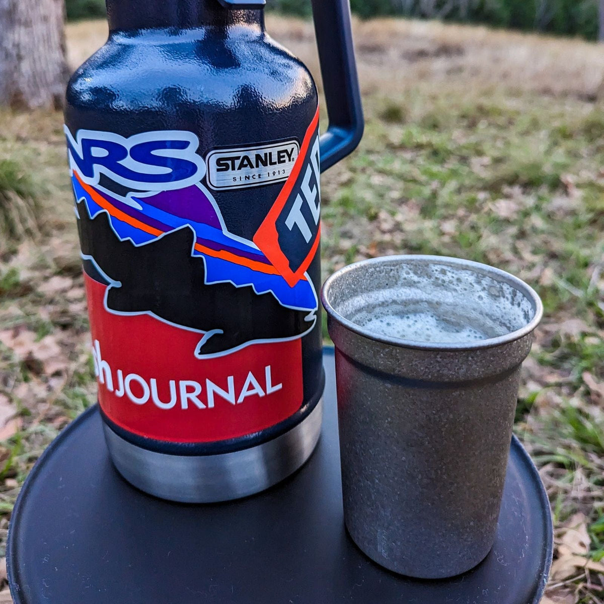 SilverAnt Ultralight Titanium Beer Cup 400ml/14fl oz - Actual product photo, lifestyle shot, real life still, outdoors, camping scene, standing with Stanley bottle