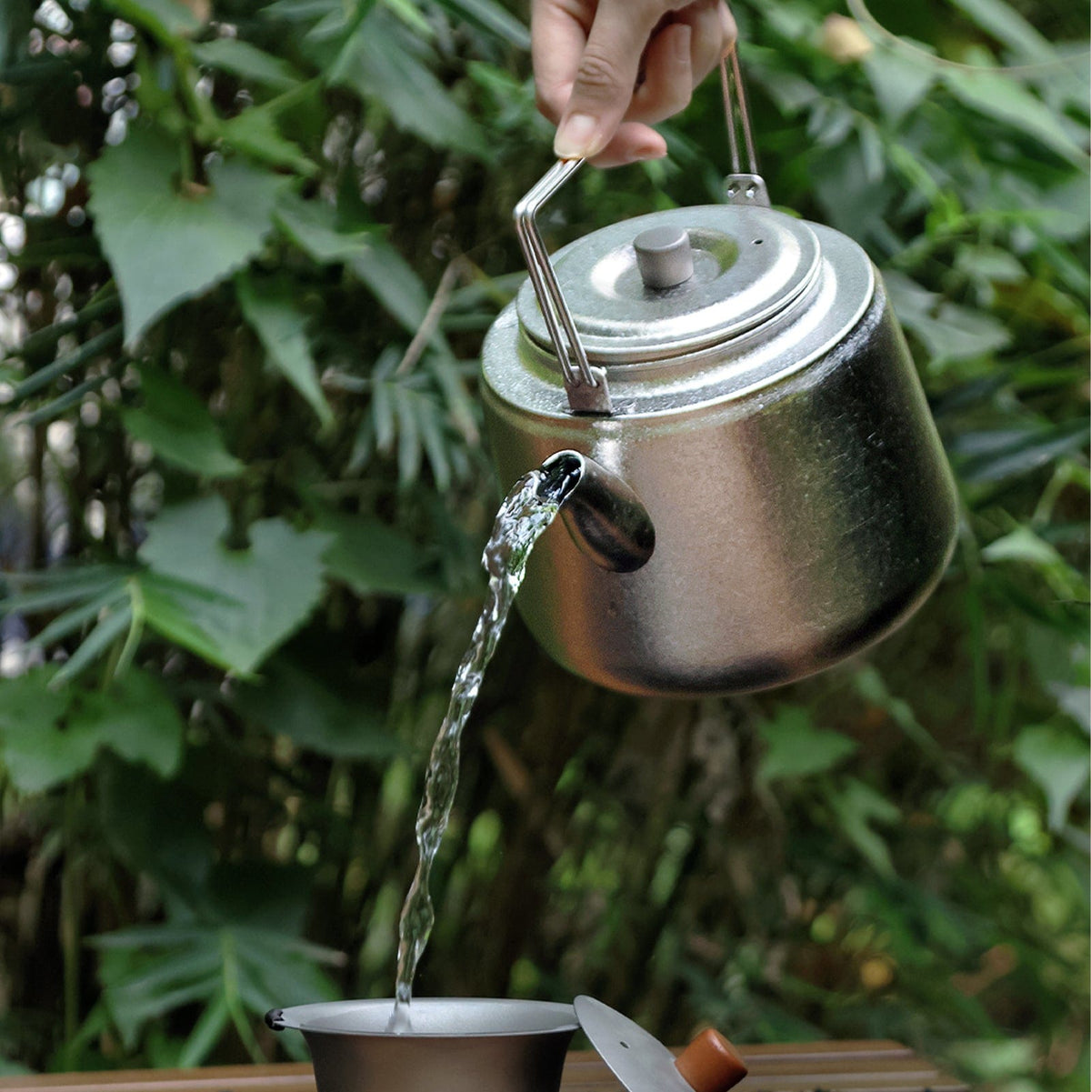 SilverAnt Ultralight Titanium Bushcraft Kettle Crystallized Finish - In-Use (pouring water, leaves in the background)