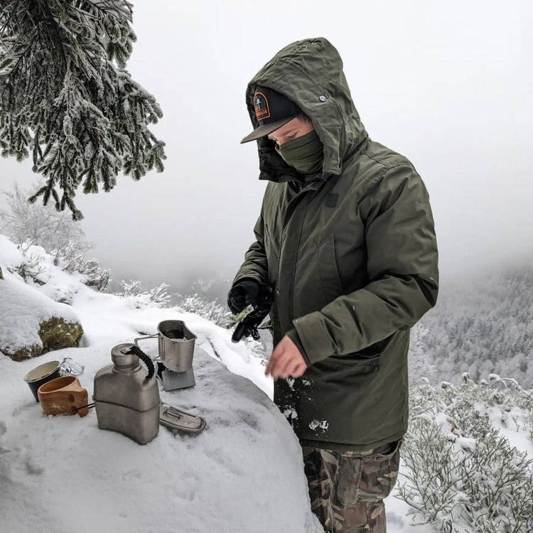 
                  
                    SilverAnt Ultralight Titanium Canteen Military Mess Kit - In-Use (making tea in winter, actual product photo, lifestyle photo, man wearing green jacket makes tea with Military Mess Kit)
                  
                