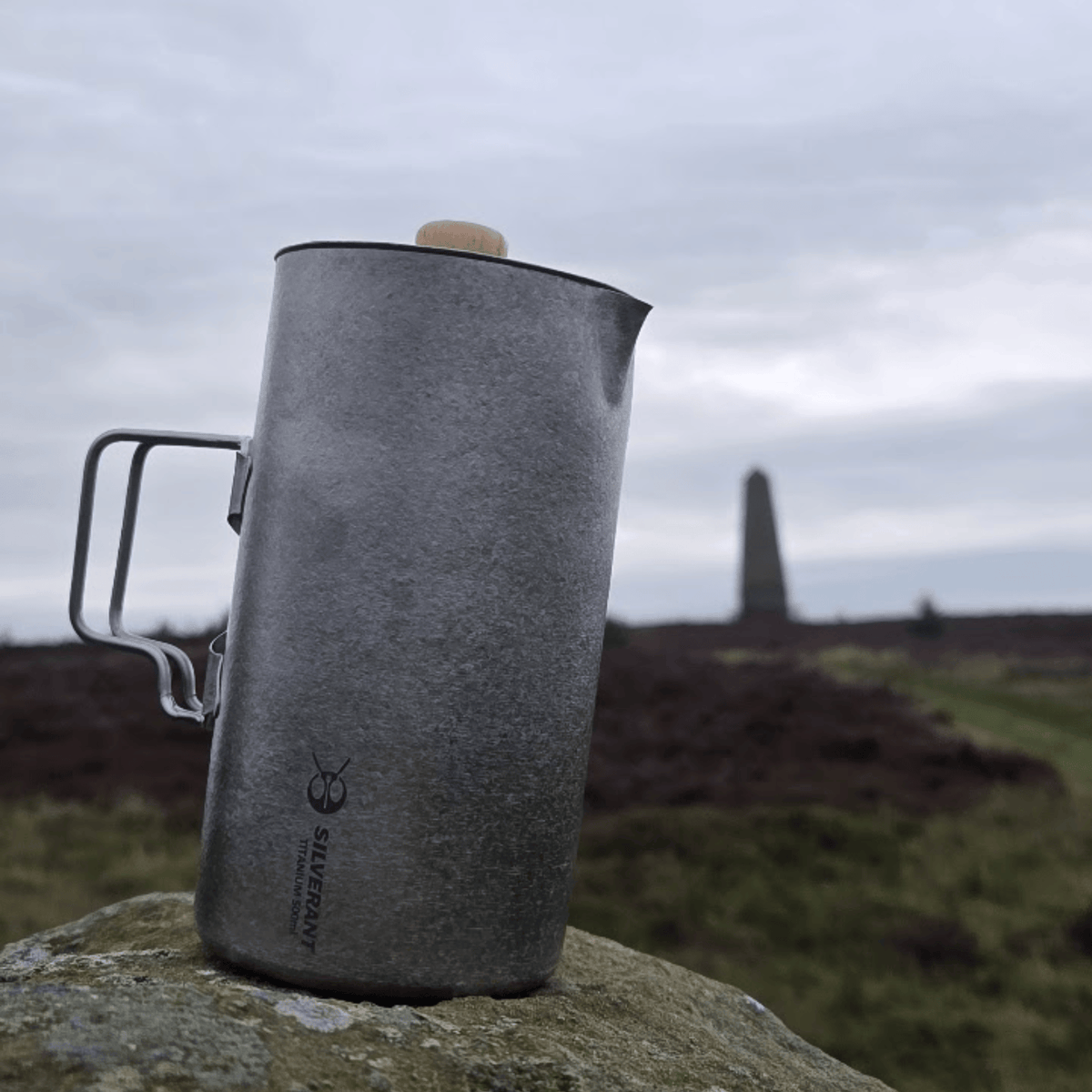 SilverAnt Ultralight Titanium Coffee French Press Crystallized - Actual product photo, lifestyle shot, placed on top of a rock, grey skies in background