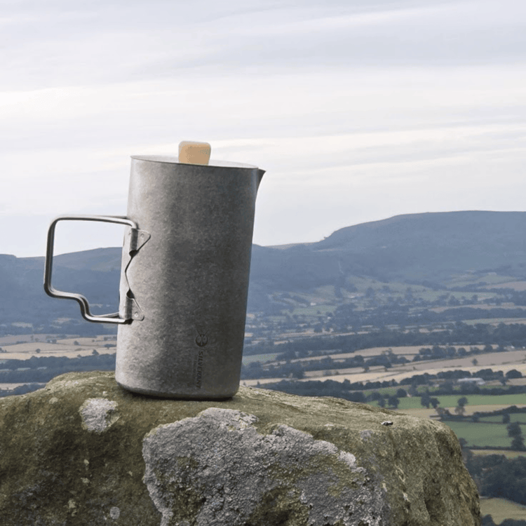 
                  
                    SilverAnt Ultralight Titanium Coffee French Press Crystallized - On top of a rock, overlooking a forested mountain view, lifestyle shot, actual product photo
                  
                