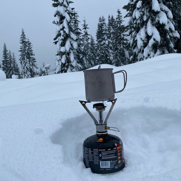 
                  
                    SilverAnt Ultralight Titanium Cup With Lid 4 Sizes - 400ml - actual product photo, winter camping, real life use, on top of a gas stove
                  
                
