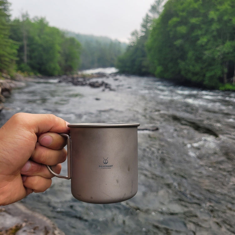 
                  
                    SilverAnt Ultralight Titanium Cup With Lid 4 Sizes - 400ml - Actual product photo, on hand, in use, river background
                  
                