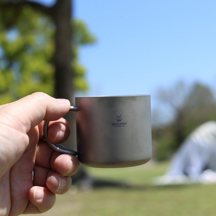 
                  
                    SilverAnt Ultralight Titanium Double Wall Espresso Coffee Cup 110ml/3.71 fl oz With Handle - Actual product photo, lifestyle shot, on hand, held out with left hand, camp coffee
                  
                