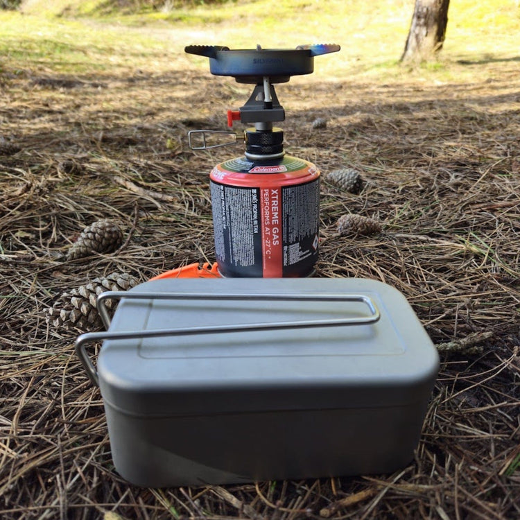 
                  
                    SilverAnt Ultralight Titanium Mess Tins - In-Use (placed on forest floor, grass, SilverTi gas stove in the back, mess tin on the foreground)
                  
                