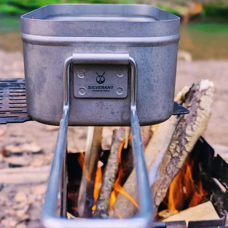 
                  
                    SilverAnt Ultralight Titanium Mess Tins - In-Use (close-up of SilverAnt branding, mess tin placed over fire)
                  
                