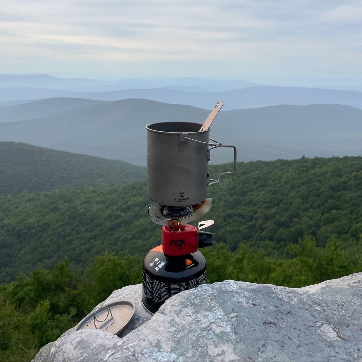 SilverAnt Ultralight Titanium Pot 750ml/25 fl oz with Lid and Bail Handle - In-Use (boiling water on a gas stove, forest background, amazing view)