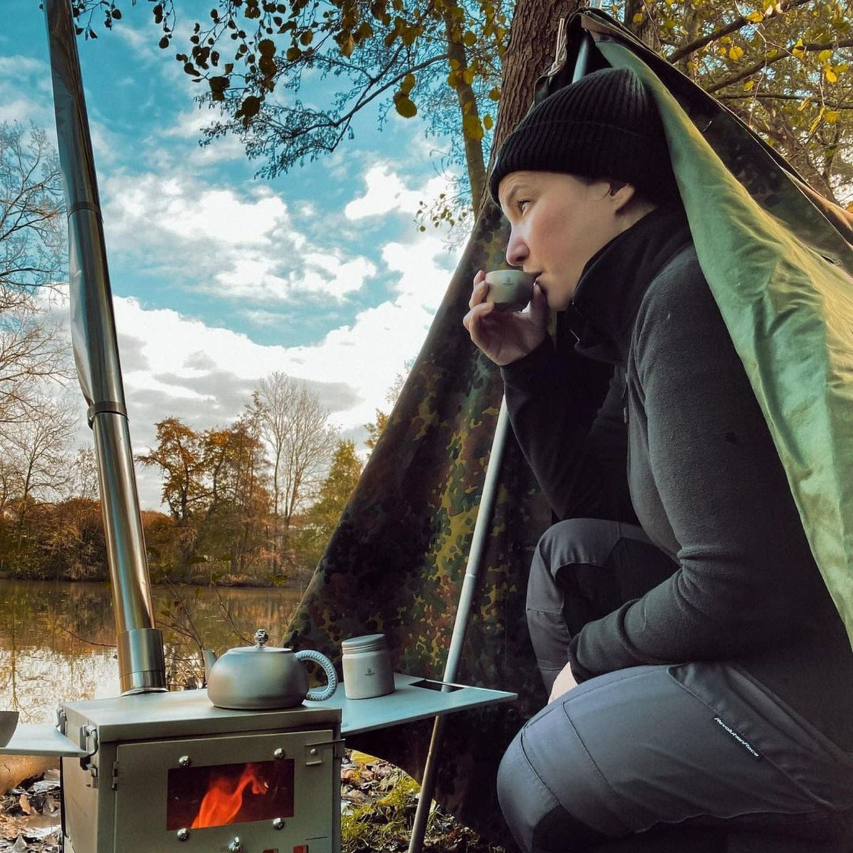 SilverAnt Ultralight Titanium Teapot & Traditional Tea Set - actual product photo, real-life use, drinking tea from titanium tea cup, wood stove, lifestyle shot, in use