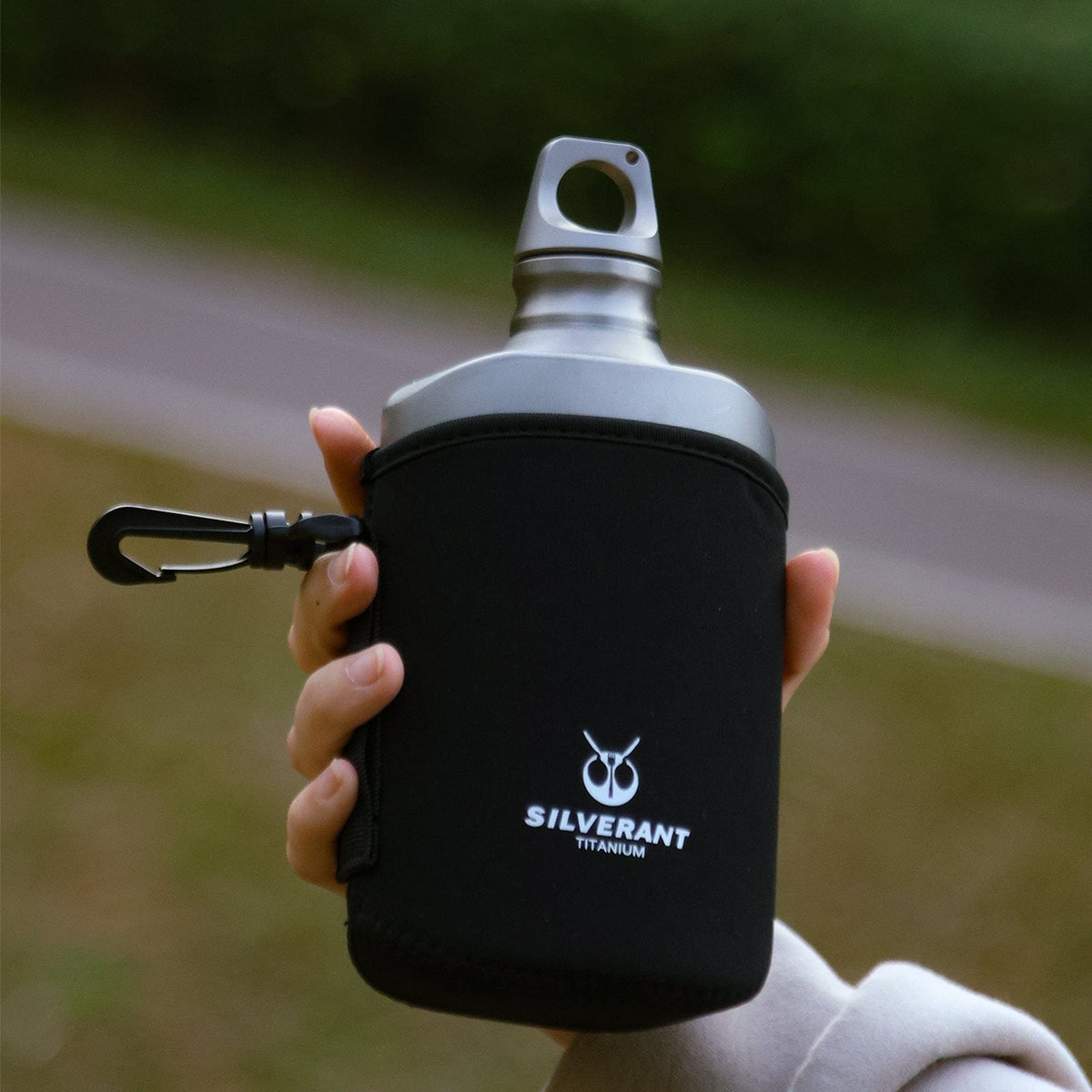 SilverAnt Ultralight Titanium Water Bottle 600ml/21 fl oz Slim - Sandblasted (Actual product photo, lifestyle shot, black thermal sleeve, on-hand, in-use)