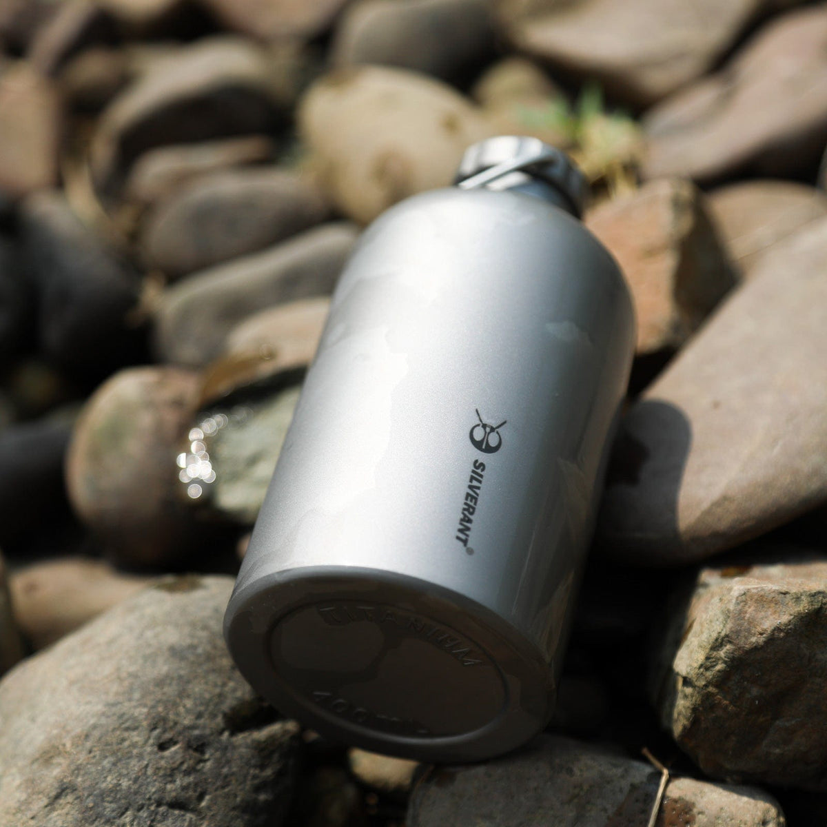 SilverAnt Ultralight Titanium Water Bottle Narrow Mouth Design - actual product photo, lifestyle shot, laid down in rocks