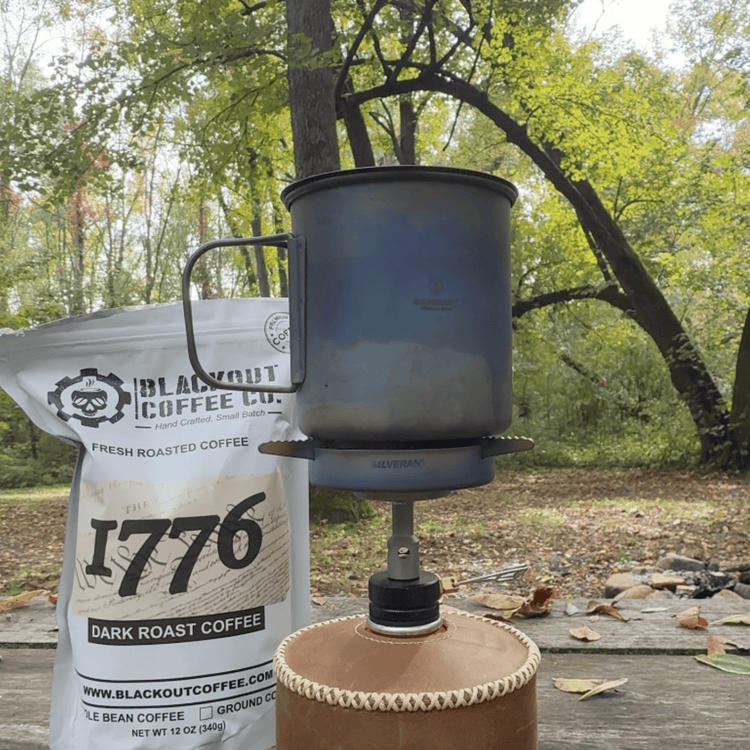 
                  
                    SilverTi Ultralight Titanium Gas Stove - Actual product photo, with Silverant titanium cup on top, unignited, with coffee pouch in background, nature, outdoors
                  
                