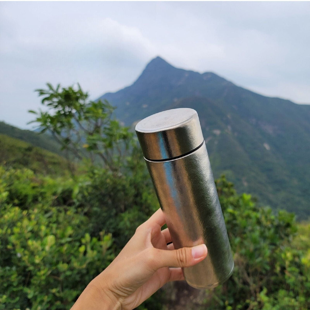 Titanium Double-Wall Insulated Thermos Flask 400ml/14fl oz - crystallized finish, on-hand, beautiful mountain view in the background