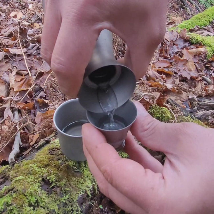 
                  
                    Titanium Sake Bottle 330ml/10.5 fl oz -  pouring sake from the bottle to the lid cup
                  
                