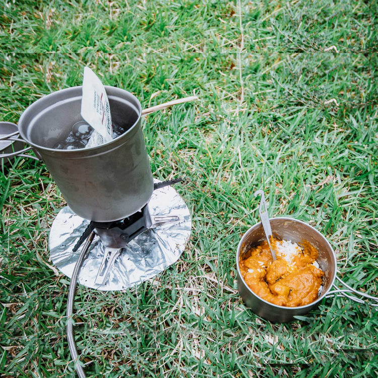 
                  
                    SilverAnt Ultralight Titanium 3-Piece Camping Cookware Set - In-Use (cooking in grass, front view, rice, curry, lunch, camp meal)
                  
                