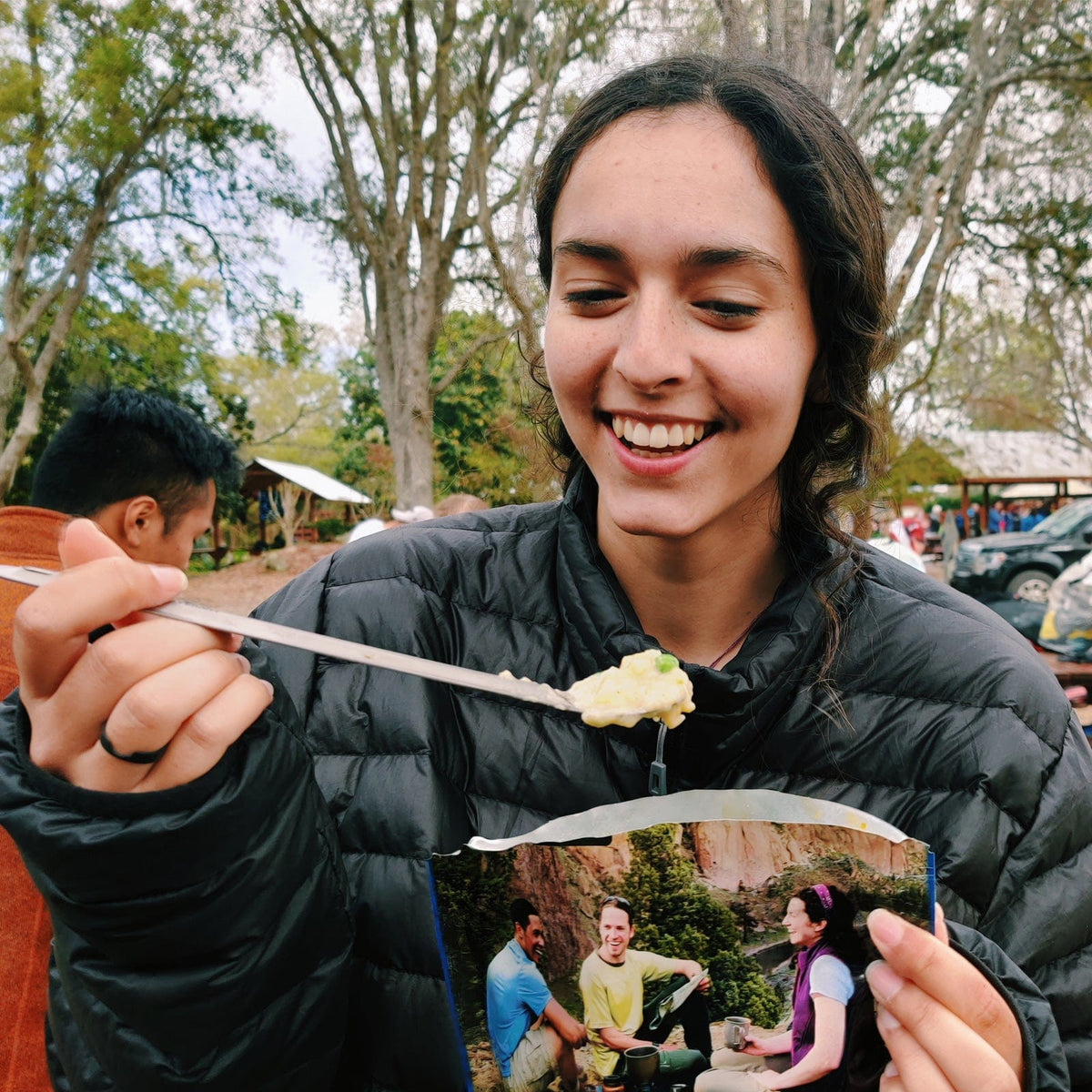 SilverAnt Ultralight Long Handle Titanium Spork Polished - actual product photo, woman uses it to eat some soup at camp from food pack, in use, real life setting
