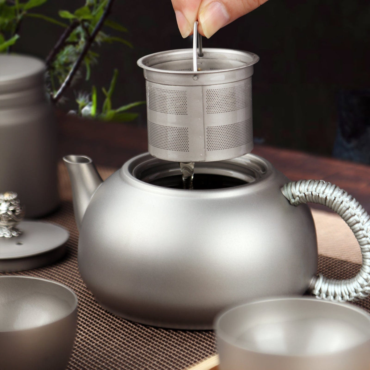 SilverAnt Ultralight Titanium Teapot & Traditional Tea Set - actual product photo, tea filter lifted out of the tea pot, in use, real life photo lifestyle shot