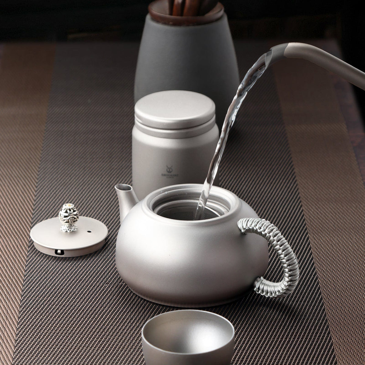 SilverAnt Ultralight Titanium Teapot & Traditional Tea Set - actual product photo, lifestyle shot, pouring water onto tea pot, professional shot, real life, in-use