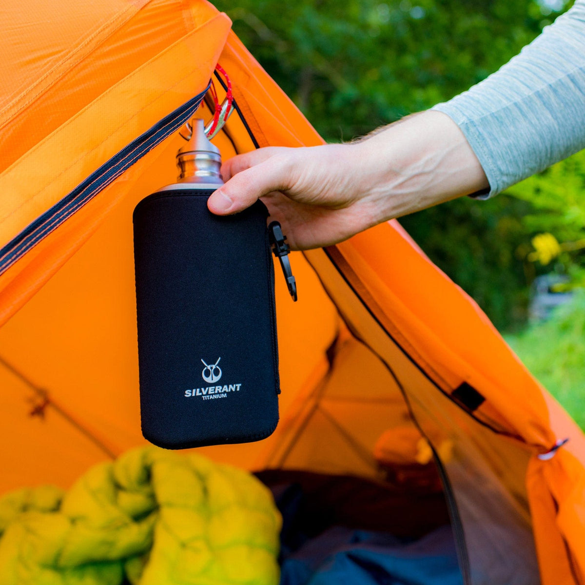 SilverAnt Ultralight Titanium Water Bottle 800ml/28.16 fl oz (Slim Sandblasted) - In-Use (held by hand hanging on a carabiner on the tent, thermal sleeve, silverant branding)