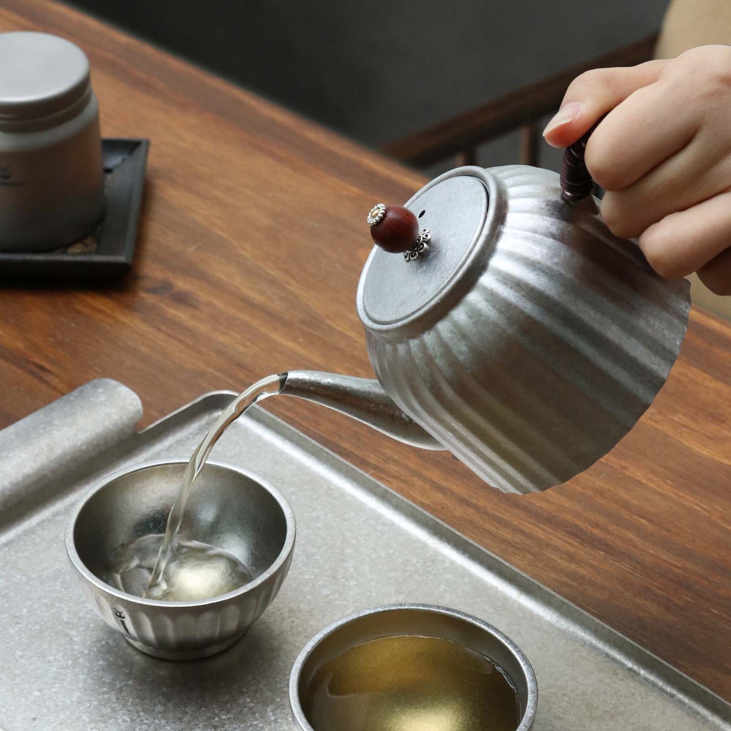 
                  
                    Titanium Pour Over Tea Pot 400ml/14fl oz - pouring tea into a tea cup
                  
                